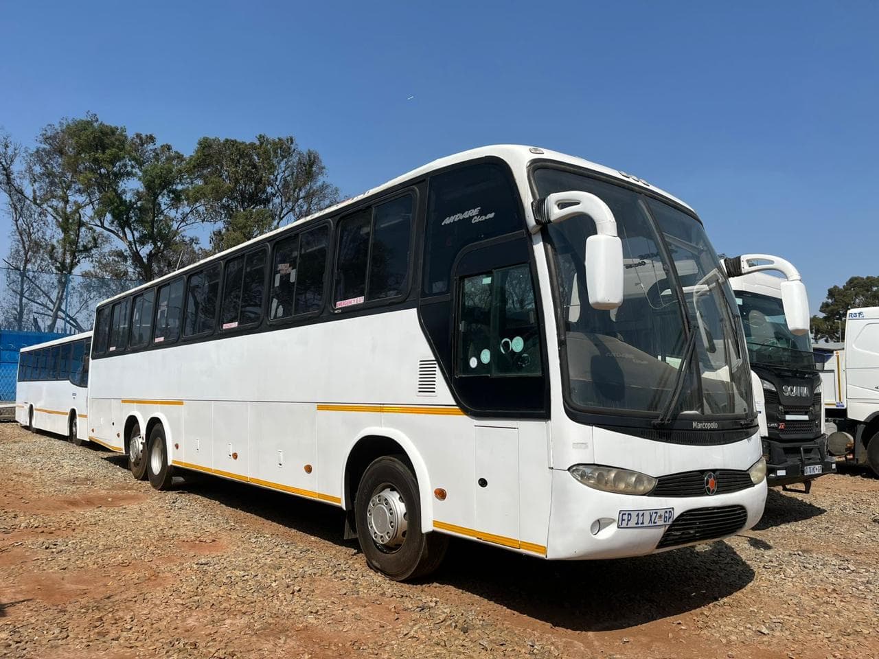 A white passenger bus parked at a depot.