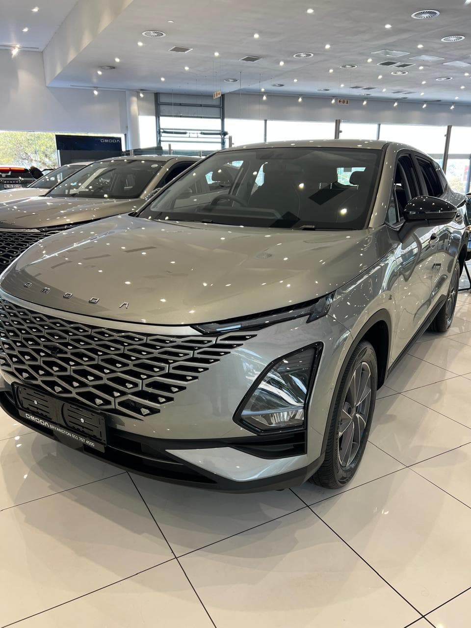 A clean, used silver sedan parked in a warehouse.